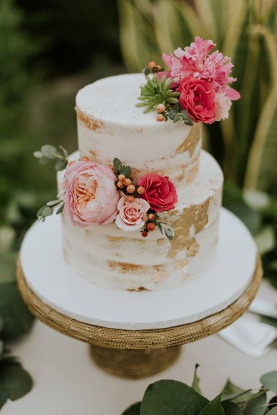 a three tiered cake with flowers on top