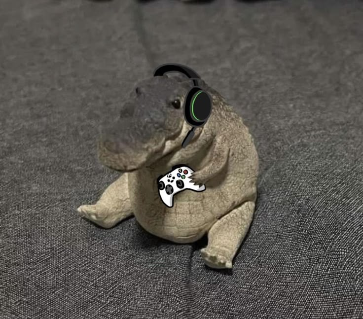 a stuffed hippo with headphones sitting on a bed