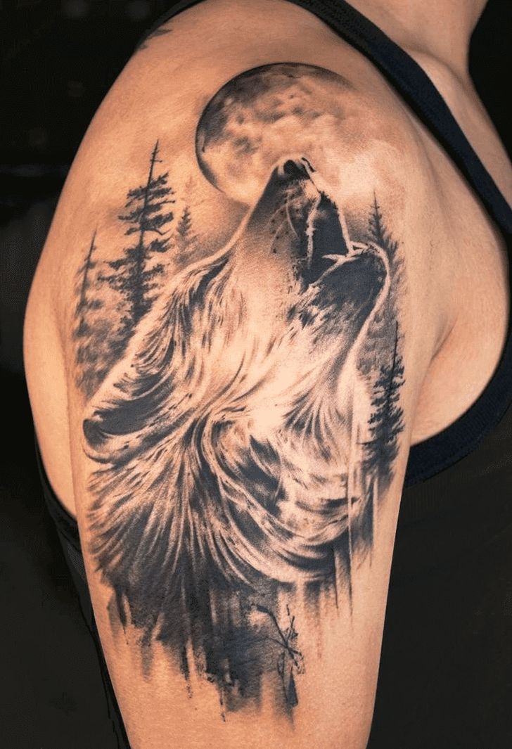 a man's arm with a wolf tattoo on it and trees in the background