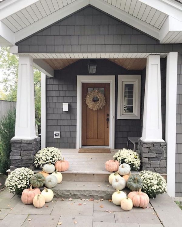 front porch decorated for fall with pumpkins and gourds