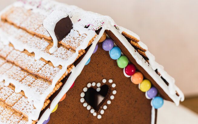 a gingerbread house with white icing and candies