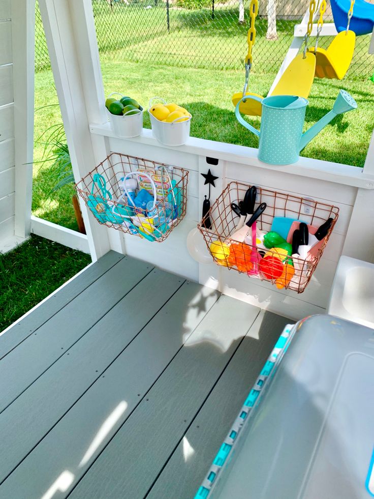 two baskets filled with toys on top of a porch