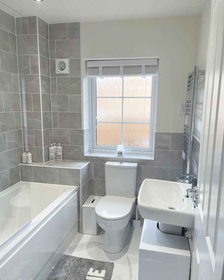 a white toilet sitting next to a bath tub in a bathroom