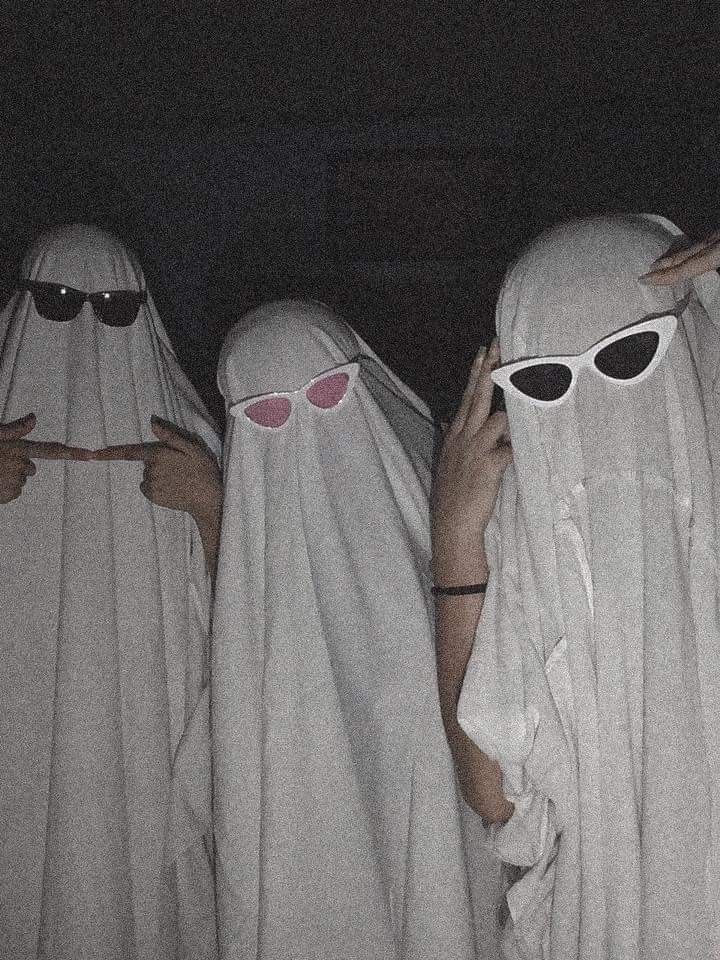 three people in white robes and sunglasses covering their faces