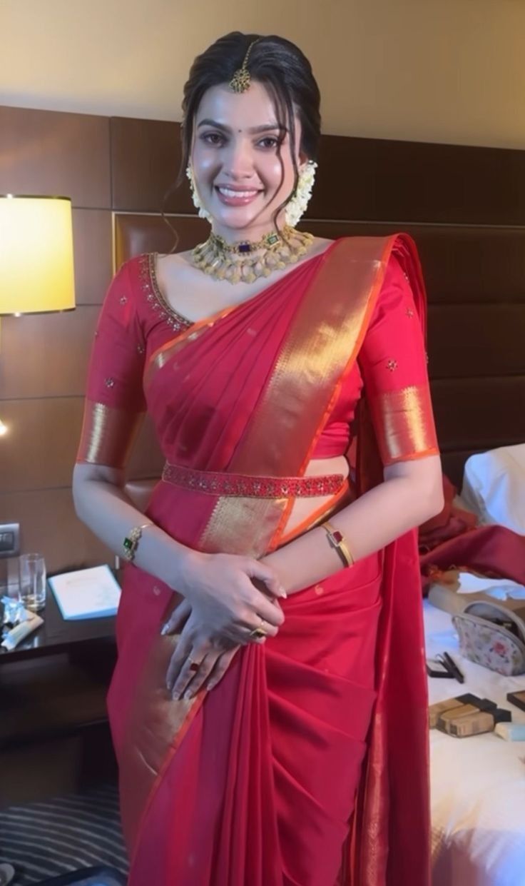 a woman in a red sari posing for the camera