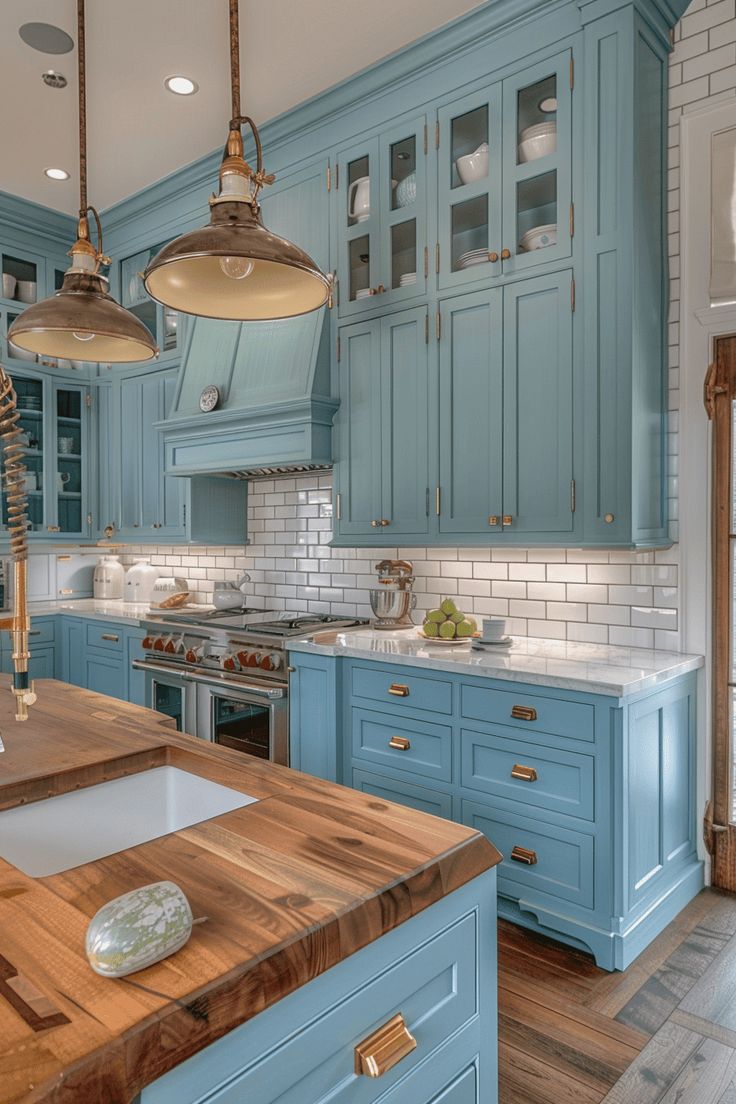 a kitchen with blue cabinets and wooden counter tops, an island in front of the sink