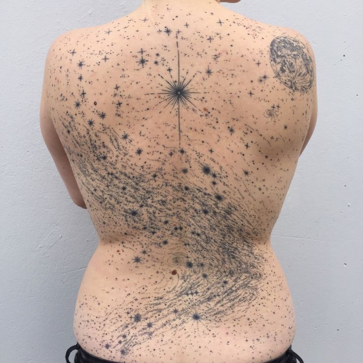 the back of a woman's body with black spots on it and stars in the sky