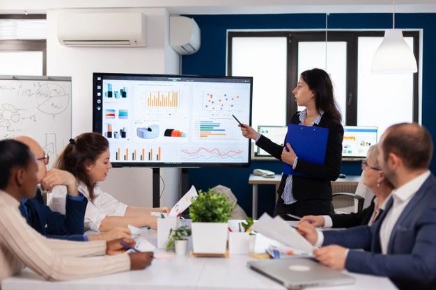 a woman giving a presentation to her colleagues