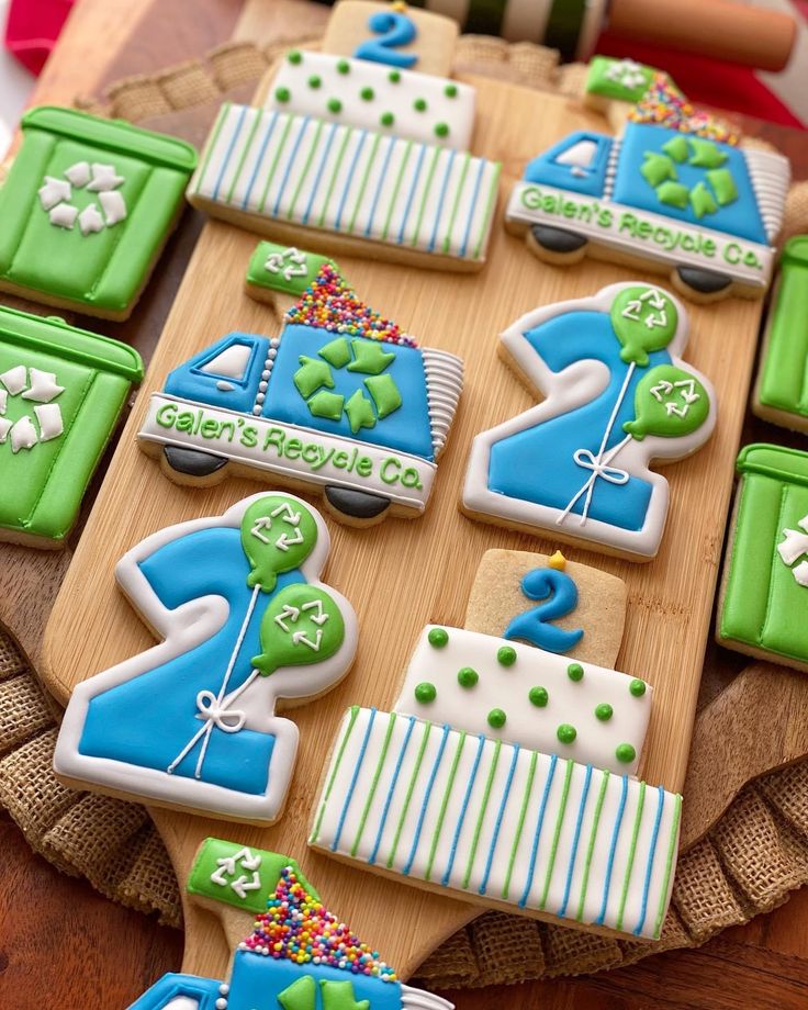 decorated cookies are arranged on a wooden platter and ready to be served at a baby's first birthday party