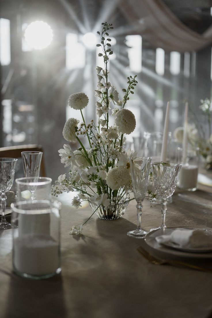 the table is set with white flowers and candles