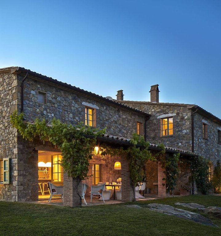 a stone house with an outdoor dining area