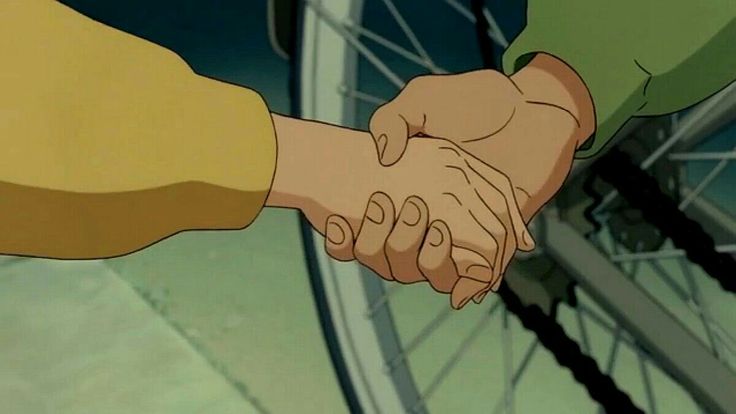 two people shaking hands in front of a bicycle