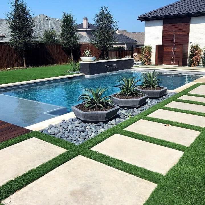 a backyard with a swimming pool and landscaping