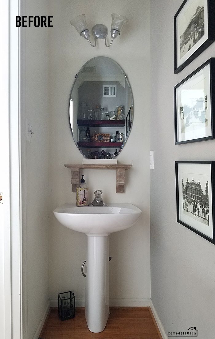 a bathroom with a sink, mirror and pictures on the wall