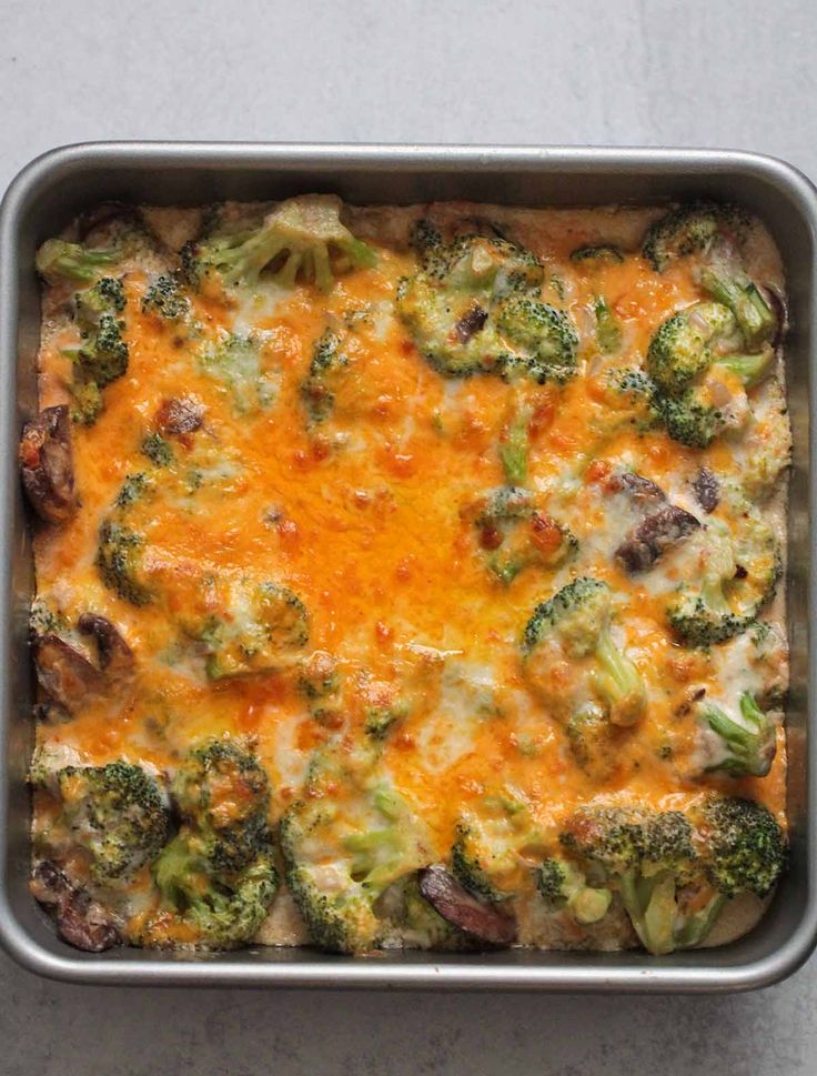 a casserole dish with broccoli and cheese in it on a table