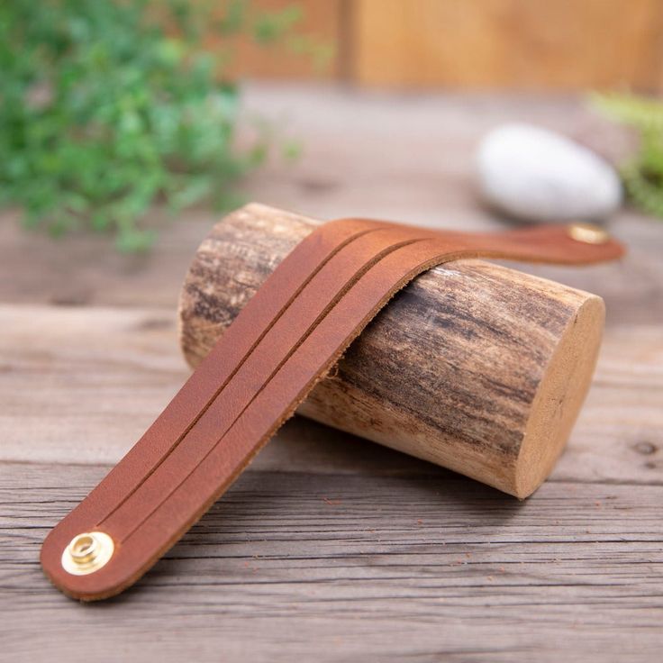 a brown leather strap sitting on top of a piece of wood