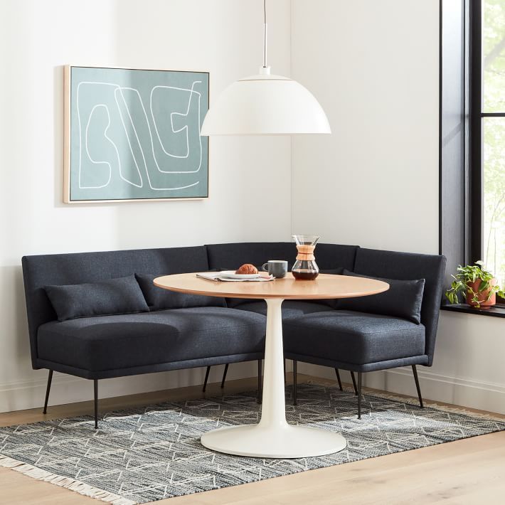 a living room area with a couch, table and potted plant on the floor