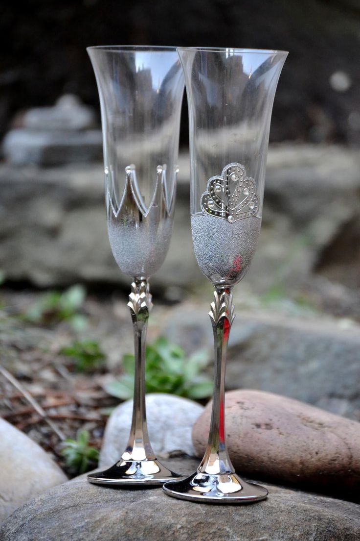 two wine glasses sitting on top of a rock