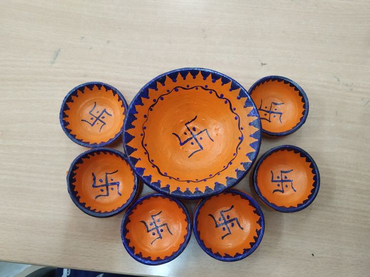 six orange and blue bowls with writing on them are arranged in a circle around each other