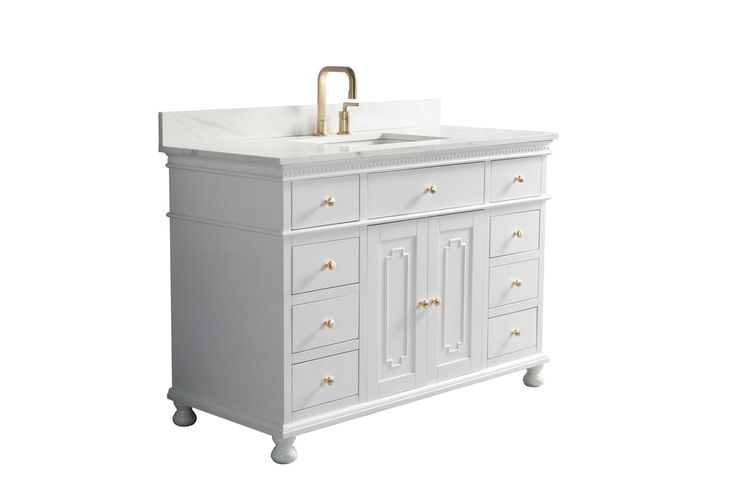 a white bathroom vanity with a gold faucet