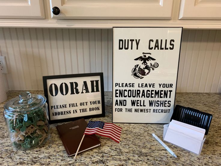 a counter top with two signs and an american flag in a glass jar on it