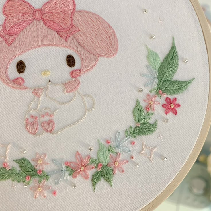 a close up of a embroidery on a hoop with a hello kitty in the center