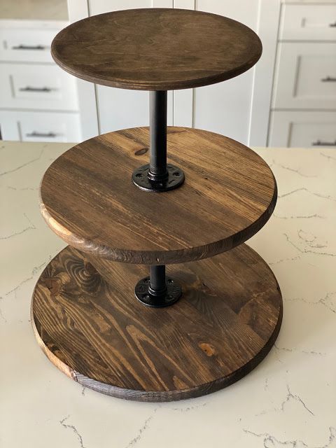 three tiered wooden cake stand sitting on top of a counter