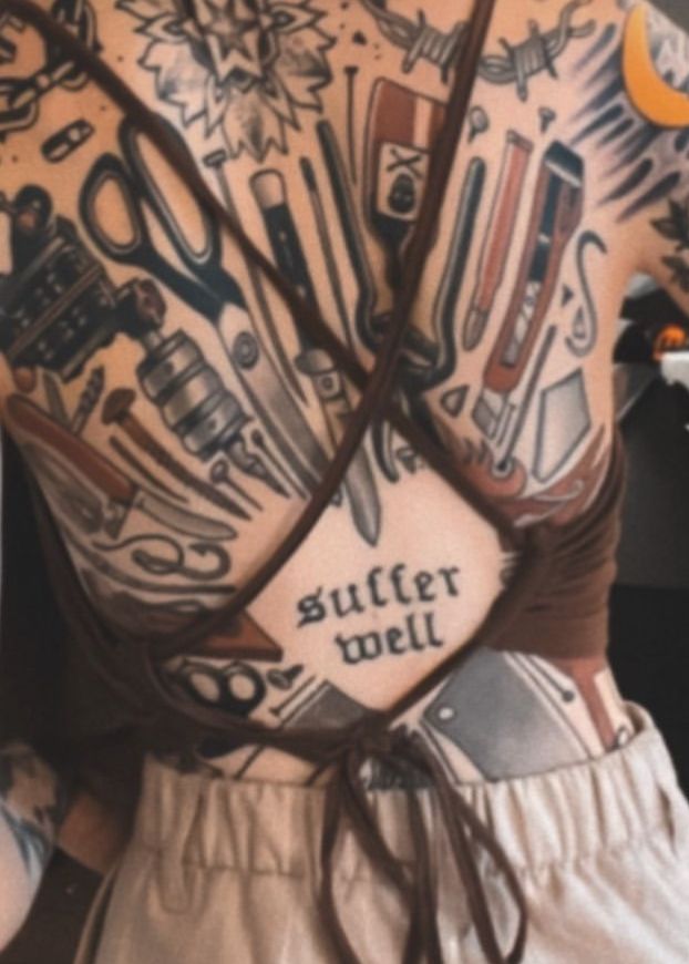 a woman with tattoos on her back has scissors and other tools tattooed on her body