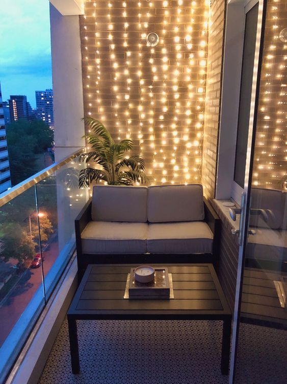 a living room with lights on the wall and couches in front of a window