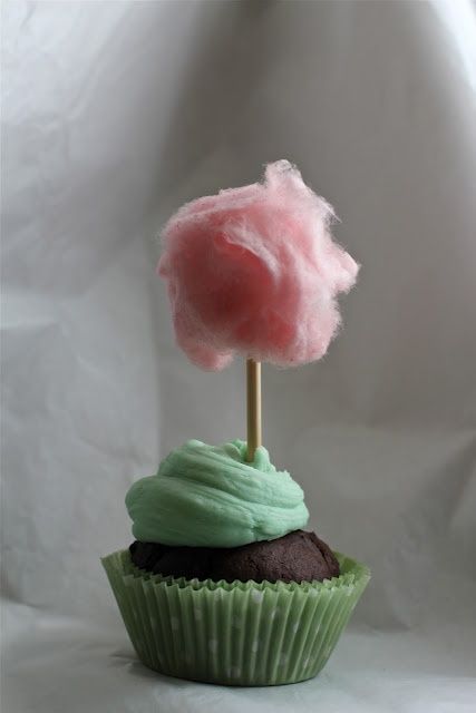 a cupcake with green frosting and a pink cloud on top is shown in front of a white background