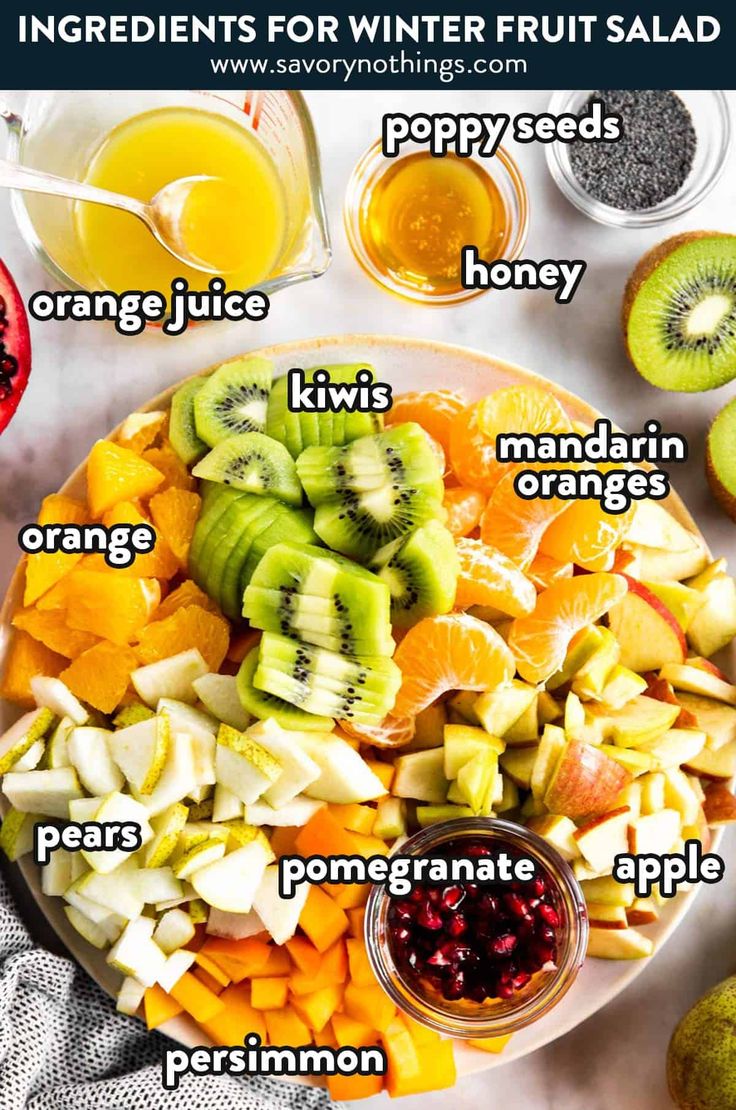 the ingredients for winter fruit salad are displayed on a plate with oranges, kiwis, pomegranate and apples