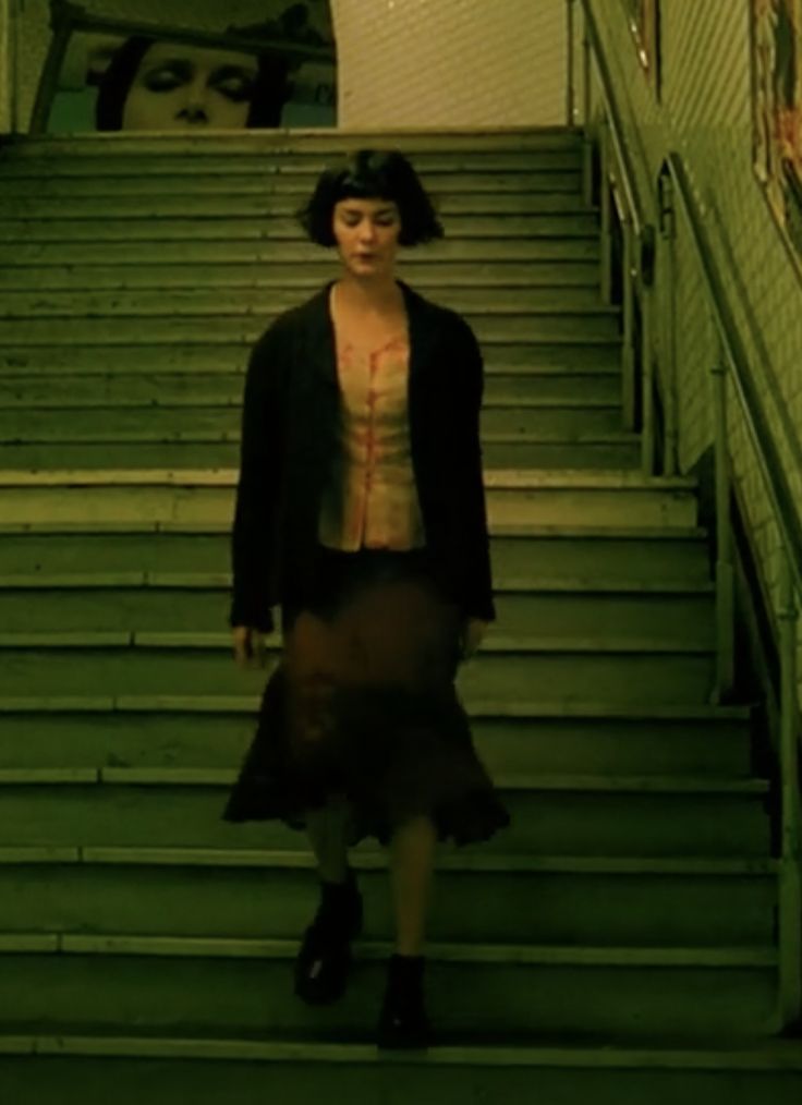 a woman walking down some stairs with her shirt on