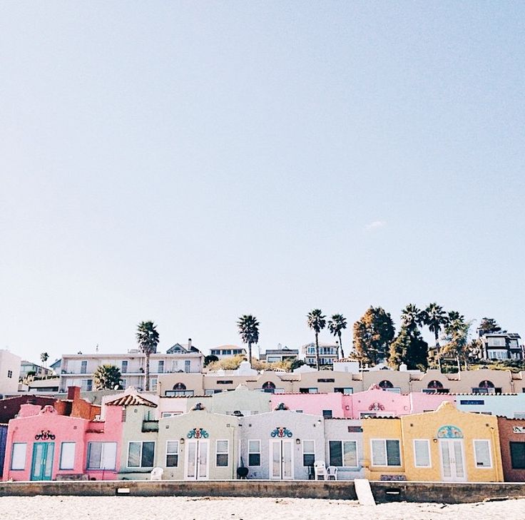 a row of colorful houses sitting on top of a beach