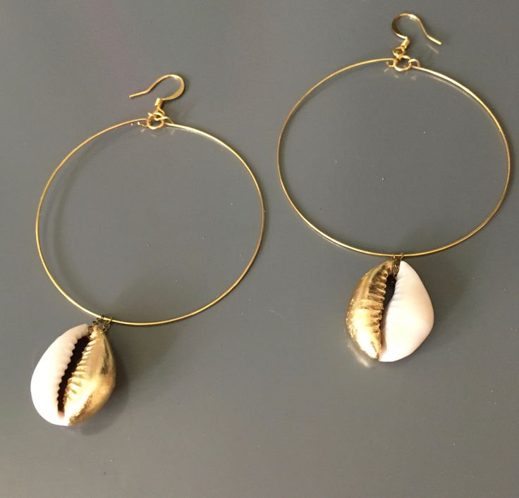 The cowrie shell once utilized as exchange currency, is revered as a symbol of fertility, goddess protection, wealth, and powerful in its connection to the strength of the ocean.  These shells have been hand leafed with gold tone leaf, base metal hoops and ear wires.  Few pairs available as these are custom made to order. Spiritual Gold Shell-shaped Jewelry, Spiritual Gold Shell Jewelry, Gold Teardrop Jewelry For Beach, Gold Teardrop Jewelry For The Beach, Gold Pierced Hoop Earrings For Beach, Gold Metal Hoop Earrings For Beach, Gold Small Hoop Earrings For The Beach, Gold Hoop Jewelry For Beach, Gold Small Hoop Jewelry For The Beach