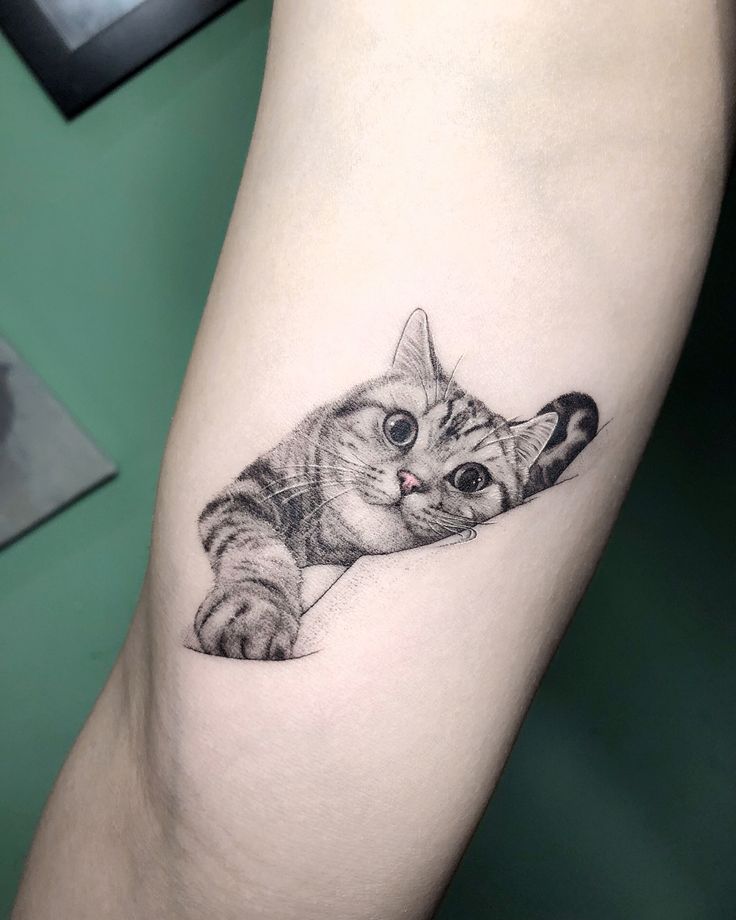 a small cat tattoo on the leg