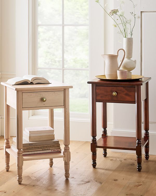 two small tables with books and vases on them