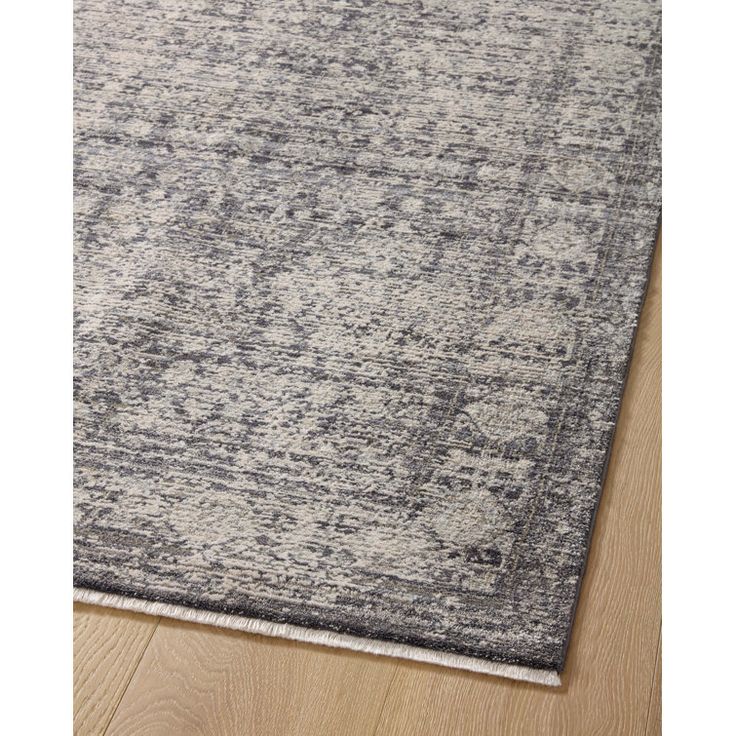 a gray and white rug on top of a wooden floor