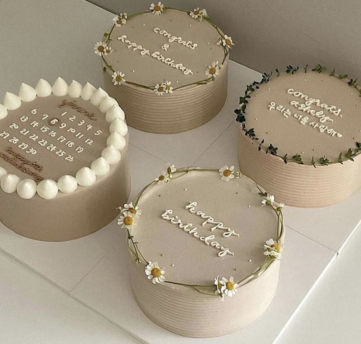 three decorated cakes sitting on top of a white counter next to each other with the words happy birthday written on them