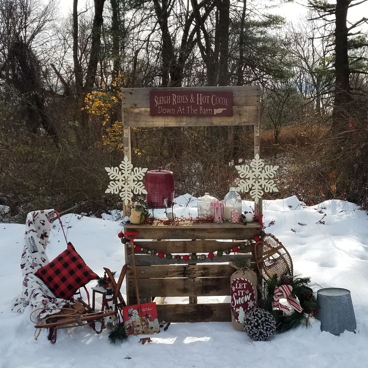 an outdoor christmas display with snowflakes and plaid blankets on the ground in front of a sign that reads santa's hot cocoa