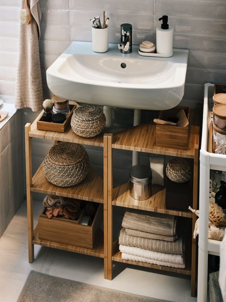 a bathroom sink sitting next to a wooden shelf