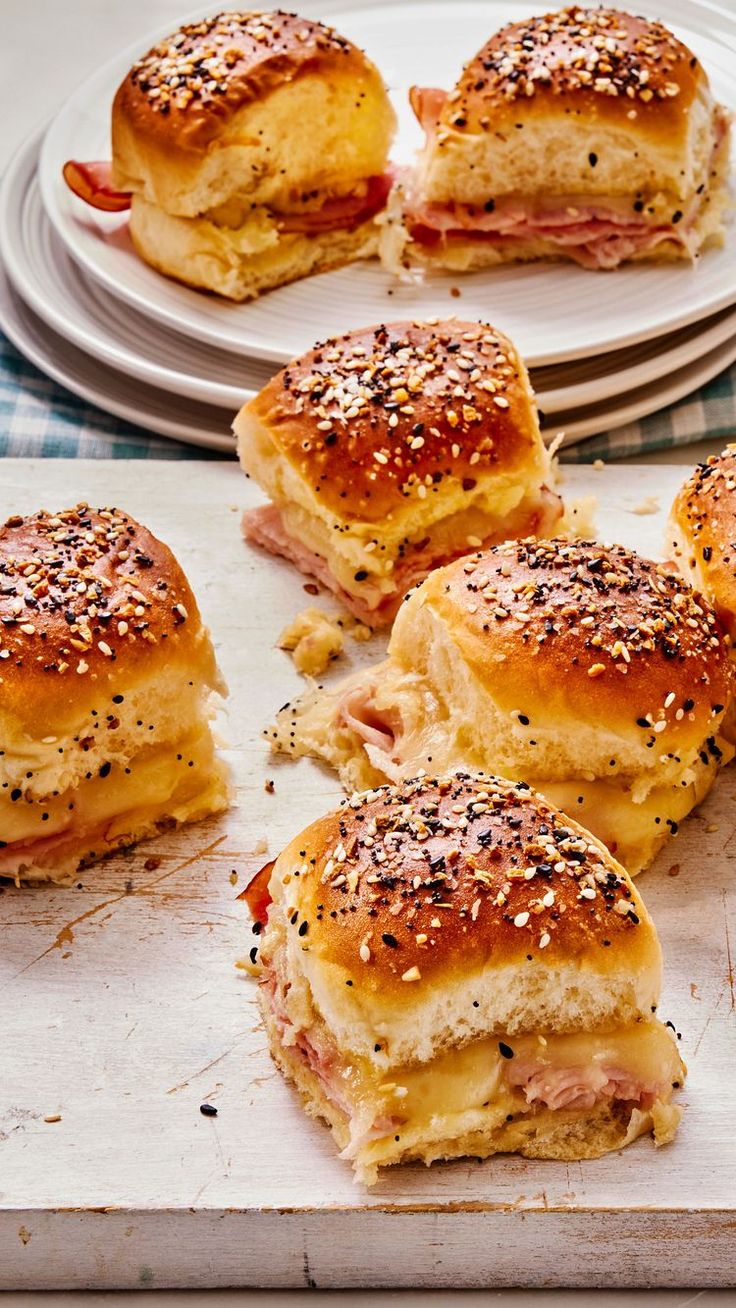 ham and cheese sliders on a tray with plates in the backgroung