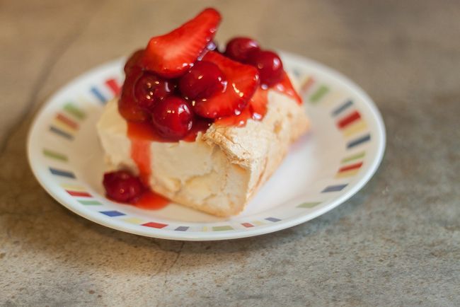 there is a dessert with strawberries and cream on the plate next to other foods