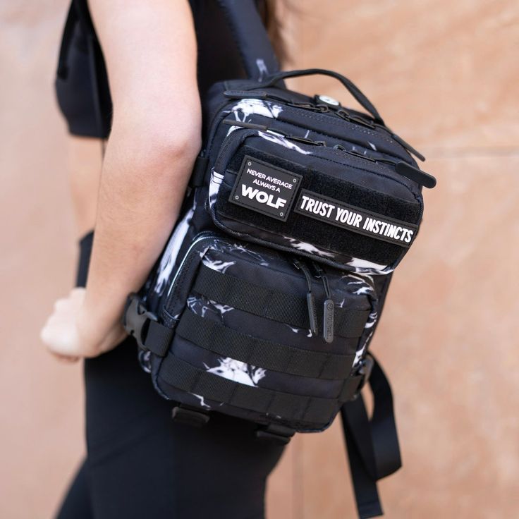 a person wearing a black and white backpack with the words wolf trust their instructs on it