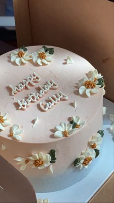 a pink birthday cake with white flowers and the words happy birthday written on it in frosting