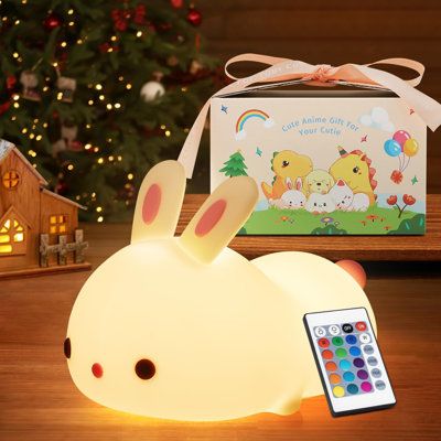 a remote control sitting on top of a wooden table next to a light up bunny