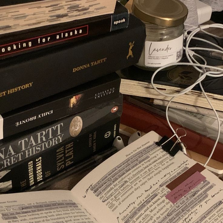 a stack of books sitting on top of a table next to a jar of jam