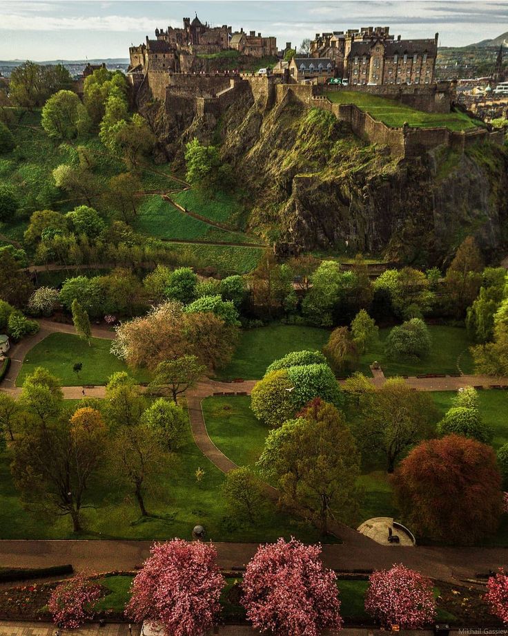 an aerial view of a castle on top of a hill with trees in the foreground