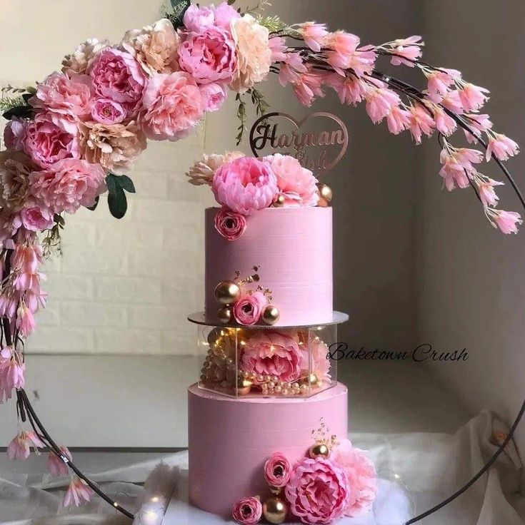 a three tiered cake with pink flowers on top