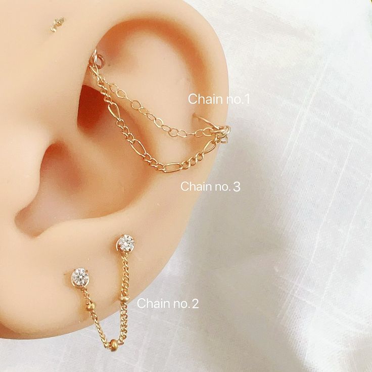 three different types of ear piercings with chains attached to the end of each one