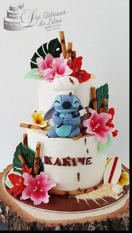 a three tiered cake decorated with flowers and an elephant on the top is sitting on a tree stump